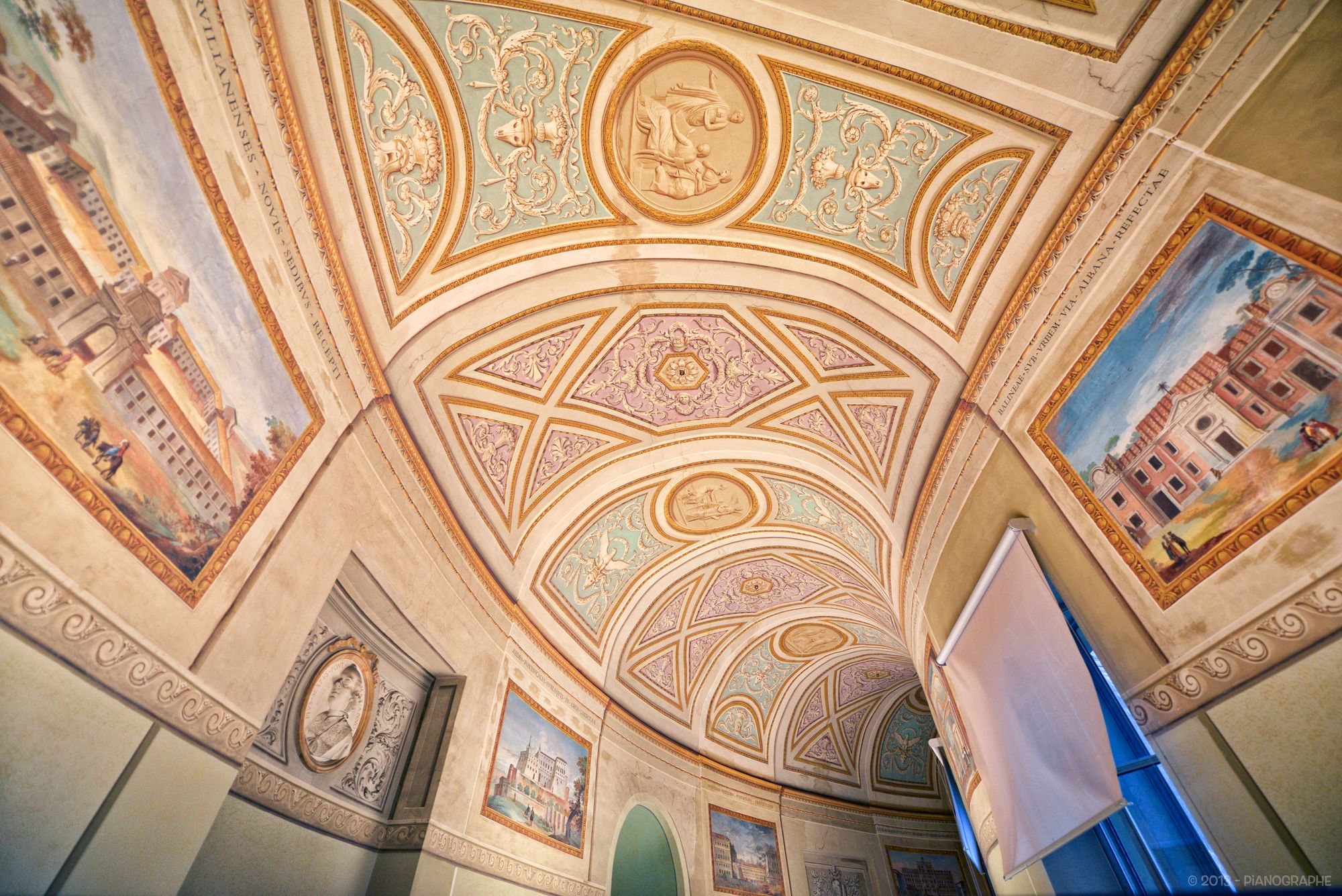 Couloir du musée arborant de nombreux ornements, voûte peinte, tableaux peints à même les murs en trompe-l'œil